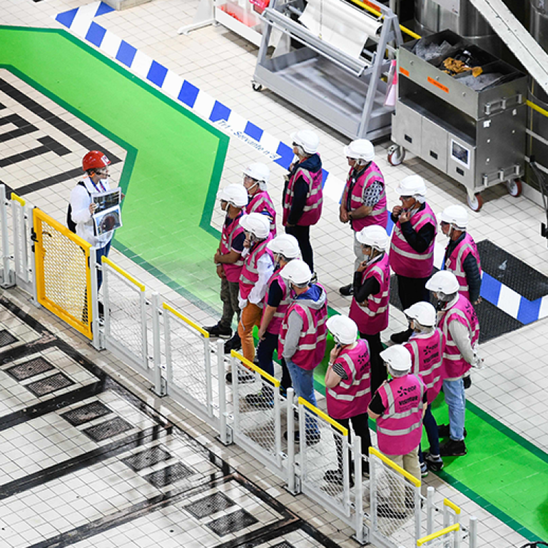 visiteurs en salle des machines avec un guide